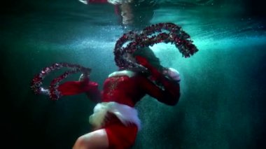 Mutlu Noeller ve yeni yıl, kadınlar su altında süslü süslemelerle oynuyor, inanılmaz sualtı çekimi.