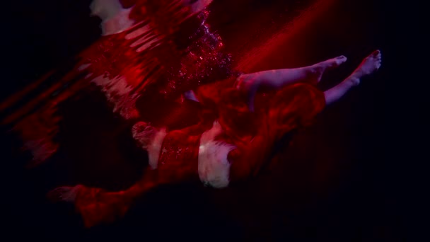 Misteriosa figura femenina en la profundidad del lago rojo mágico, mujer está girando dentro del agua — Vídeos de Stock
