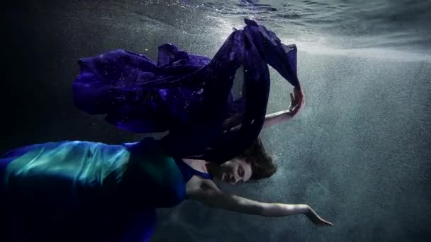 Загадочный и драматичный подводный кадр, женская фигура тонет в глубине моря или озера — стоковое видео