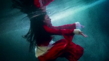 Güzel peri masalı prensesi kışın, suyun altında, nehrin soğuk sularında yüzüyor.