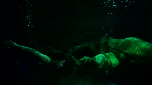 Дві жінки в костюмах русалки плавають в глибині басейну або акваріума, під водою — стокове відео