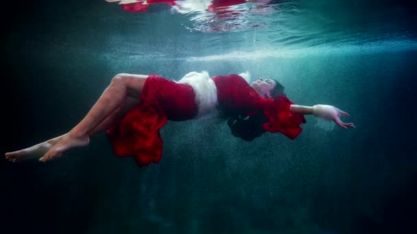 Anmutige Frau schwebt in kaltem Wasser, Unterwasseraufnahmen, Fantasie und Traumkonzept — Stockvideo