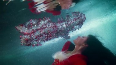 Diğer dünyaların gizemli görüntüleri suyun içinde, kadın suyun altında yüzüyor ve yukarı çıkıyor.