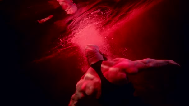 거대 한 근육을 가진 강력하고 힘있는 사람을 물 속에서 생생하게 쏘아 올린 보디빌더가 깊은 곳에서 다이빙을 하고 있다 — 비디오