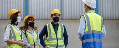 Üniformalı ekip çalışması mühendisi koruma maskesi takıyor. Beyin fırtınası atölyesi endüstriyel fabrika binası. toplantı işçi takımı.