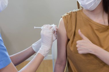 Female doctor giving vaccinations to patient for protection. During outbreak of COVID-19. Doctors vaccinate patients during epidemic.