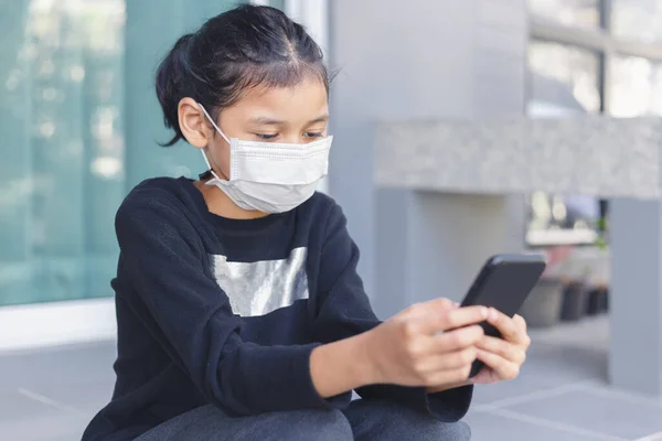 Child Girl Wear Face Mask Covid Outbreak Using Smartphone Study — Zdjęcie stockowe