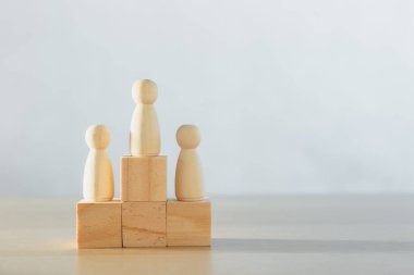 Tahta insanlar podyumda tahta bloklarda duruyorlar. Organizasyon için yetkin bireylerin seçimi. İş yarışması sıralaması. insanlar şirket başarısı.