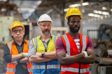 Bir grup mühendis başarılı takım çalışanları fabrikada duruyor. Takım çalışması teknisyeni müfettişi imalat endüstrisi işyeri.