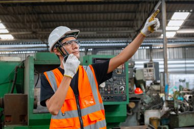 Asyalı adam mühendisliği telsiz teknisyeni sanayi işyeri imalat müfettişi tutuyor. Ağır sanayi fabrikası konsepti.