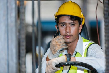 Depoda çalışan forklift kullanan profesyonel bir şoför. Fabrika endüstrisinde depolama yükleyici.