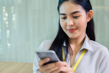 Asyalı iş kadını internette akıllı telefon kullanıyor. Ofiste çalışıyor. teknoloji iletişim ağı dijital.