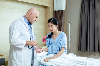 Doktor nabız kalp atış hızı olan kadın hastayı kontrol et. Muayene kalp atışı kontrolü hastanede..