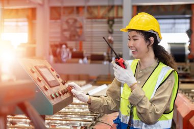 Kadın mühendis elinde telsiz kalite kontrolüyle fabrika deposunun önünde duruyor. profesyonel mühendislik makine atölyesi.