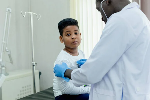 健康医療の概念 アフリカ系アメリカ人の男性医師が聴診器診断を使う子供の少年患者 — ストック写真