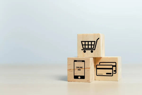 オンラインショッピングの概念 テーブルの上にショッピングや電子商取引のアイコンを持つ木製のキューブブロック ビジネスオンラインマーケティング — ストック写真