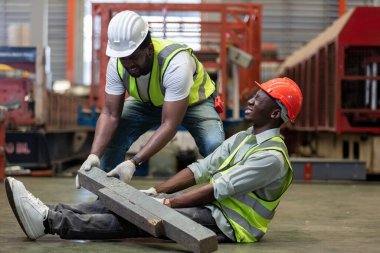 Industrial accident concept. Male african american accidents from working carrying heavy objects on legs in Industrial factory.
