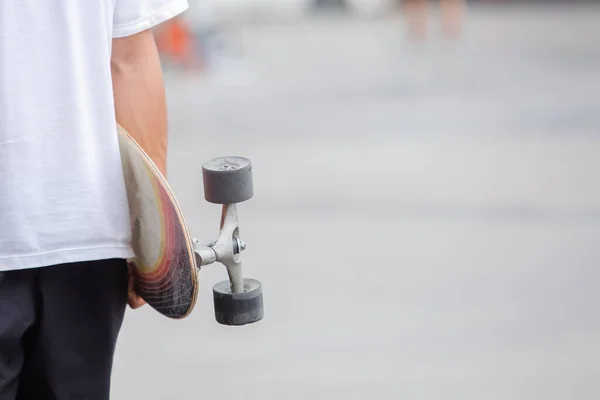 man holding skateboard on street city.  skateboarding outdoor sports. extreme sports concept.