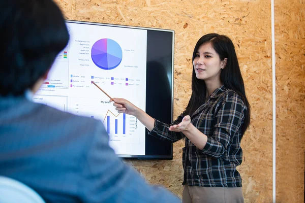 Asian young businesswoman presentation pointing digital board in meeting boardroom. brainstorming executive training business cocept.