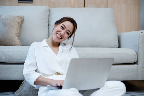 Happy young asian woman working with laptop. female smiling work at home chatting social network meeting online. reading email or shopping online.