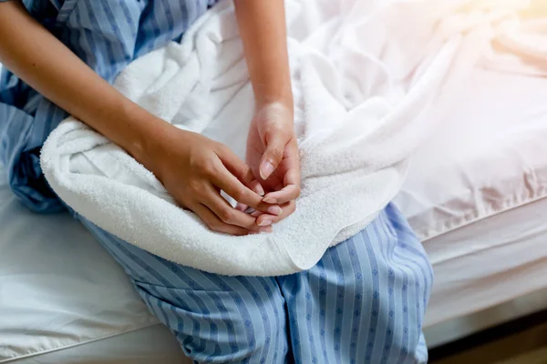 Close up hand of patient women gloomy mood sitting on bed at hospital private room. unhappy from illness. medical health care insuran.