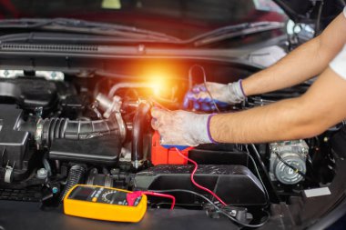 Ulaşım onarım servisi konsepti, Tamirci Oto Tamircisi Araç aküsünü kontrol ettikten sonra motor içinde kullanıldı. Erkek işçi servis motoru tamirhanesi.