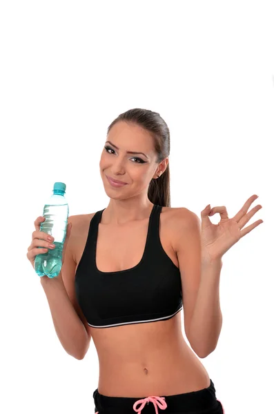 Chica de fitness sosteniendo una botella de agua y dando señal ok — Foto de Stock