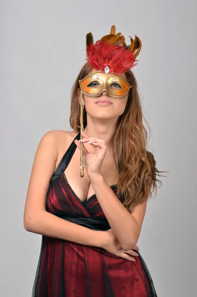 Studio portrait of an elegant arab woman posing with masquerade mask over gray background — Stock Photo, Image