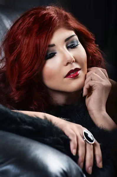 Glamorous woman resting on leather couch — Stock Photo, Image