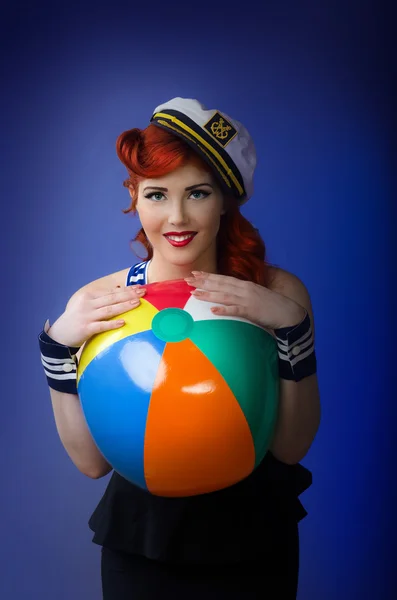 Beautiful pin up model posing with a beach ball — Stock Photo, Image