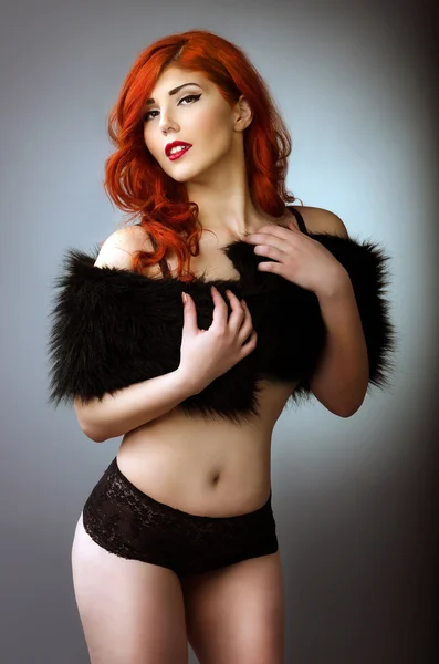 Glamorous Curvy Red Head Woman With A Sexy Body And Small Breasts Posing In  Black Lingerie On A Blue Studio Background With Vignetting Stock Photo,  Picture and Royalty Free Image. Image 156121884.