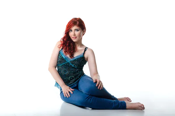 Young beautiful woman sitting on the floor, isolated on white — Stock Photo, Image