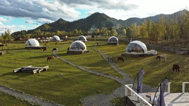 Eco hotel într-o vale în fața munților. Vedere de sus din dronă — Videoclip de stoc