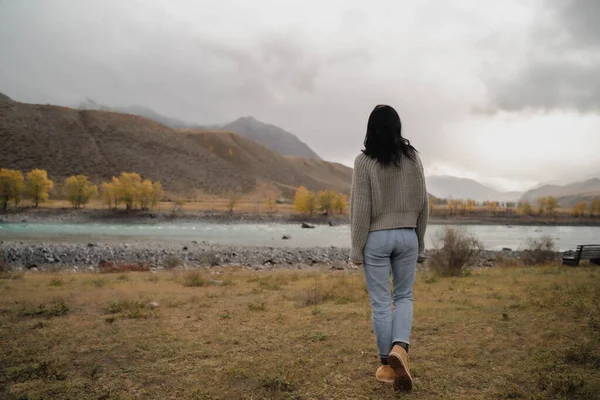 Brunette fille européenne s'en va. Dans le contexte de la rivière et des montagnes. Automne — Photo