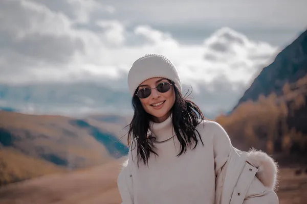 Vacker snygg flicka turist poserar mot bakgrund av vita snötoppar. Soligt. Närbild Stockbild