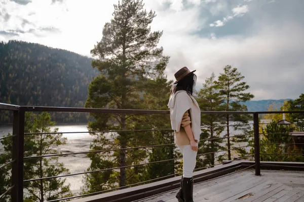 Belle fille en vêtements élégants et chapeau brun se tient sur le toit tourné et refroidir — Photo