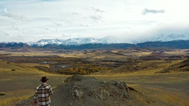 Turist adam dağa tırmanıyor. Karlı tepelerin manzarası. En üst noktadan hava fotoğrafçılığı — Stok video