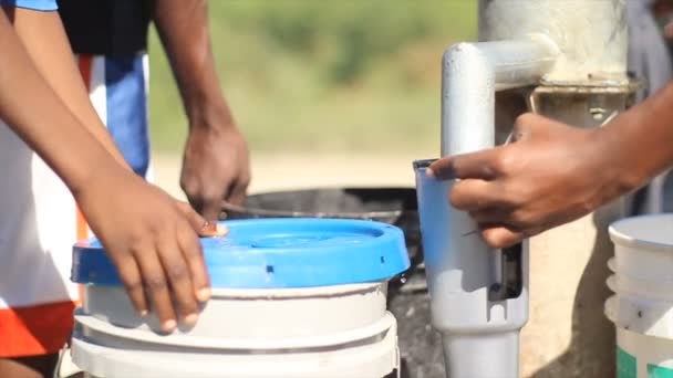 Filling up buckets at well. — Stock Video