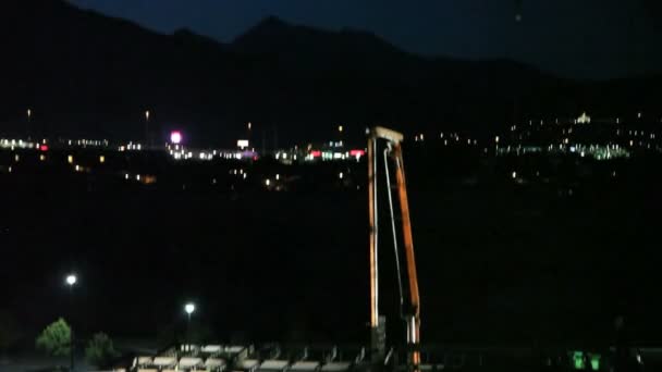 Inclinación hacia abajo del sitio de construcción por la noche . — Vídeo de stock