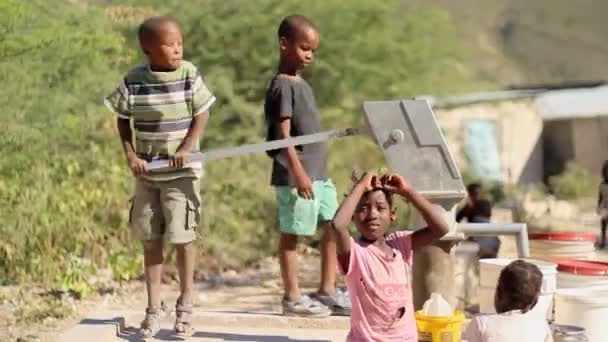 Port au prince, haiti - 17 Aralık 2013: kimliği belirsiz kişiler dışında port au prince, haiti bir kuyudan su toplama. (içerik yalnızca kullanım.) — Stok video