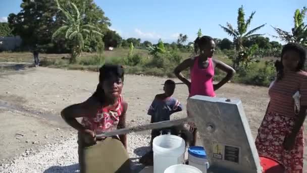 太子港，海地-2013 年 12 月 17 日: 身份不明的人在海地太子港市郊的井里抽水。(编辑仅供使用.) — 图库视频影像