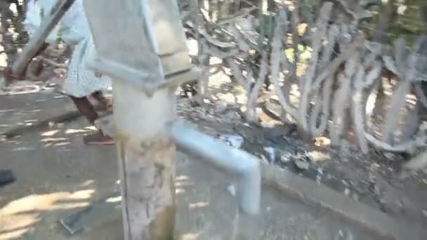 Port au Prince, Haiti - 17. Dezember 2013: Unbekanntes glückliches Mädchen pumpt Wasser in einem Brunnen am Stadtrand von Port au Prince, Haiti. (nur für redaktionelle Zwecke.) — Stockvideo
