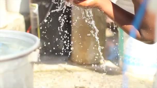 Port au Prince, Haiti - 17. Dezember 2013: Unbekannte schieben auf dem Rückweg von einem Brunnen am Stadtrand von Port au Prince, Haiti, Eimer mit Wasser. (nur für redaktionelle Zwecke.) — Stockvideo