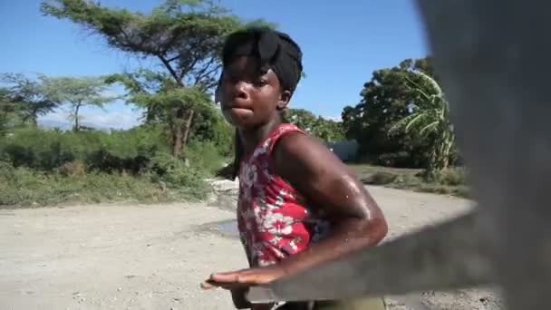 PORT AU PRINCE, HAÏTI - 17 DÉCEMBRE 2013 : Femme non identifiée pompant de l'eau à un puits dans la banlieue de Port au Prince, Haïti. (Pour usage rédactionnel seulement .) — Video