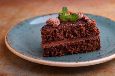 Nane şekeriyle süslenmiş siyah bir arka planda bir tabak çikolatalı kek..