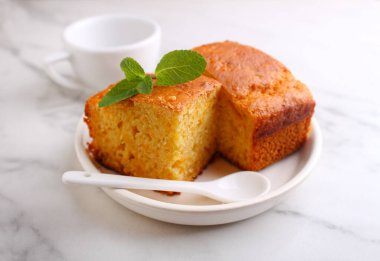 Balkabaklı Semolina keki. Parça parça kesilmiş ve naneyle süslenmiş.