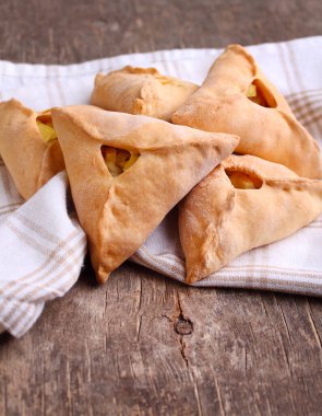 Eski ahşap bir arka planda patates, soğan ve etle doldurulmuş Rus turtaları. Geleneksel Rus yemekleri.