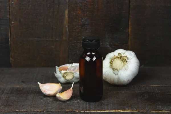 Minyak Dalam Botol Dan Bawang Putih Segar Pada Latar Belakang — Stok Foto