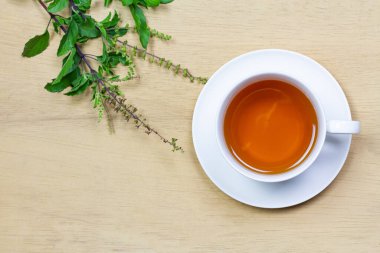 Tulsi ya da beyaz fındıklı kutsal fesleğen çayı. Arka planda ahşap bir tül dalı var. Hindistan 'da Ayurvedic tıp.