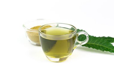 Şeffaf cam bardakta çay ve beyaz arka planda izole edilmiş taze neem yaprağı..